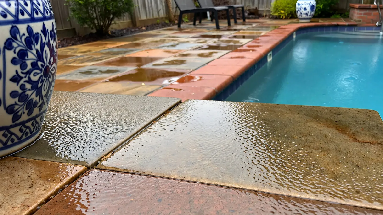 Wet outdoor tile and polished stone surfaces showing reduced traction after rainfall in residential settings.