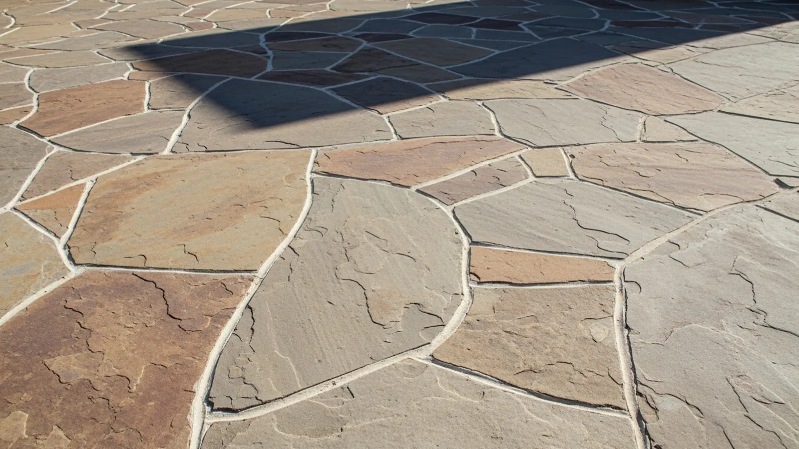 An outdoor stone surface showing subtle shifting and separation caused by long-term ground movement.